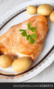 Delicious plate of baked salmon accompanied with little potatoes