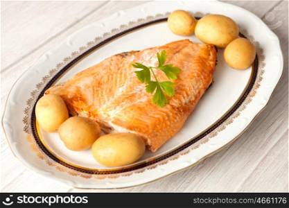Delicious plate of baked salmon accompanied with little potatoes