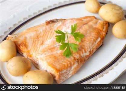Delicious plate of baked salmon accompanied with little potatoes