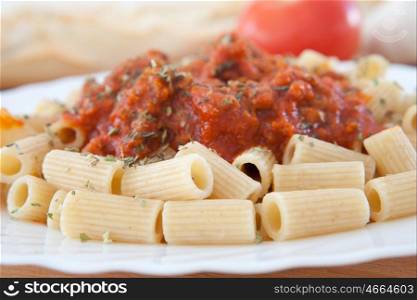 Delicious plate of macaroni with tomato close up