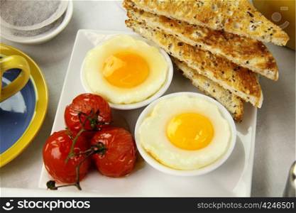 Delicious poached eggs and grilled tomatoes with toast.