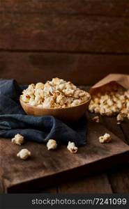 Delicious popcorn with caramel on wooden background.