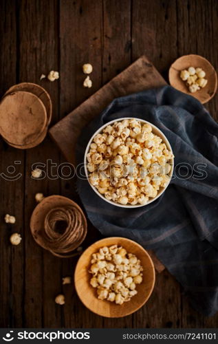 Delicious popcorn with caramel on wooden background.