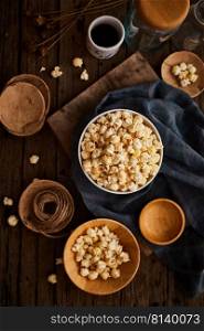 Delicious popcorn with caramel on wooden background. 