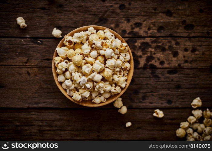 Delicious popcorn with caramel on wooden background. 