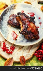 Delicious pork steak with berry sauce. Grilled pork with viburnum.