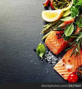 Delicious portion of fresh salmon fillet with aromatic herbs, spices and vegetables - healthy food, diet or cooking concept