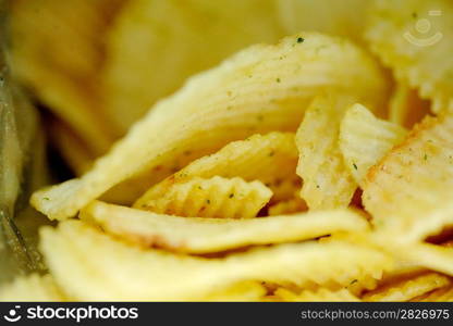 Delicious potato chips closeup on the black