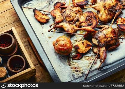 Delicious quail roasted on skewers.Chicken shashlik with apples. Quail fried on skewers