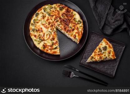 Delicious quiche with broccoli, cheese, chicken, spices and herbs on a dark concrete background