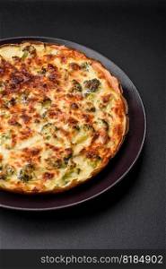 Delicious quiche with broccoli, cheese, chicken, spices and herbs on a dark concrete background