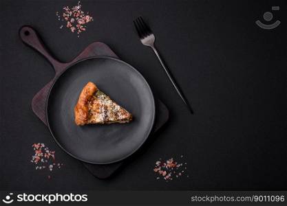Delicious quiche with chicken, cheese, herbs, spices and herbs on a dark concrete background