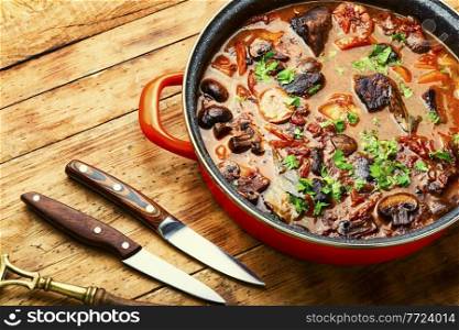 Delicious ragout with beef and mushrooms. Meat sauce with veal on wooden table. Ragout with beef and mushrooms