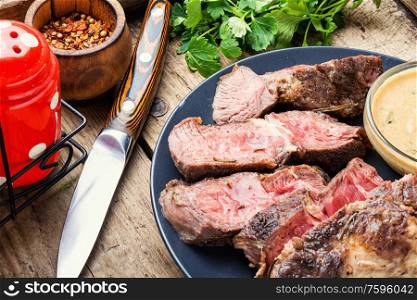 Delicious rare roast beef seasoned with fresh herbs. Roast beef with table knife