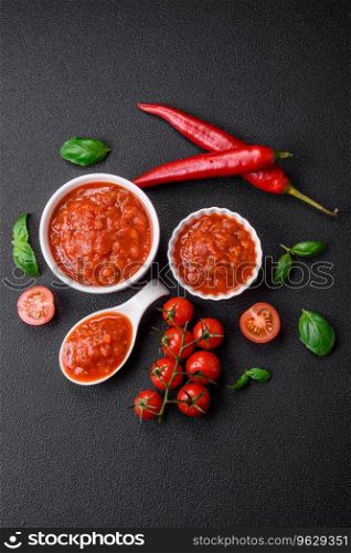 Delicious red Napoletana sauce with onions, salt, spices and herbs in a white bowl on a dark concrete background