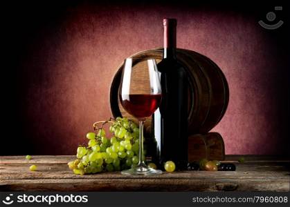 Delicious red wine with grape on wooden table