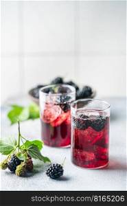 Delicious refreshing blackberry lemonade with fresh berries and ice on table against light background. refreshing blackberry lemonade