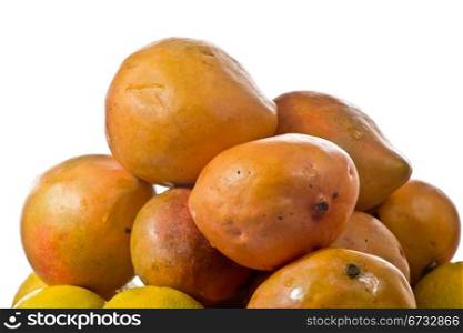 Delicious ripe mangos stacked up on a white plate