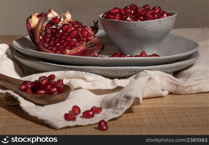 Delicious ripe pomegranate kernels in ceramic bowl on kitchen countertop. Space for text
