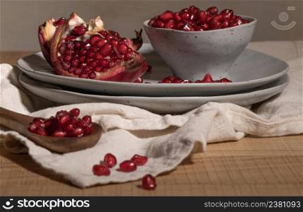 Delicious ripe pomegranate kernels in ceramic bowl on kitchen countertop. Space for text