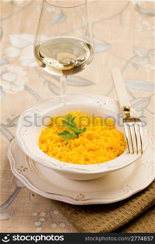 delicious risotto with saffron and golden fork on elegant table