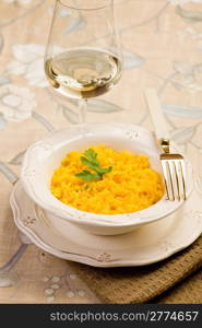 delicious risotto with saffron and golden fork on elegant table