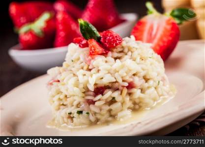 Delicious risotto with strawberries on wooden table