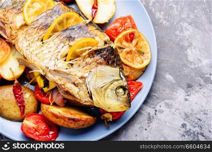 Delicious roasted fish with lemon and garnish.Tasty baked whole fish. Fish baked with vegetable garnish