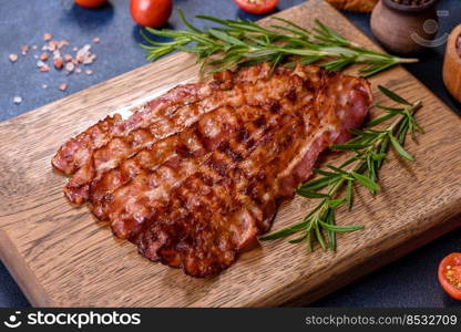 Delicious roasted ham with slices on a wooden cutting board with spices and herbs. Making a hearty breakfast. Delicious roasted ham with slices on a wooden cutting board with spices and herbs