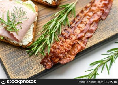Delicious roasted ham with slices on a wooden cutting board with spices and herbs. Making a hearty breakfast. Delicious roasted ham with slices on a wooden cutting board with spices and herbs