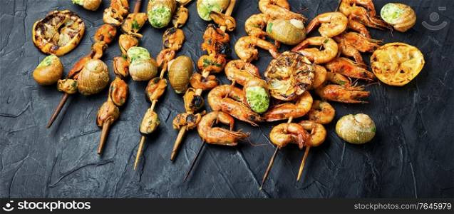 Delicious roasted shrimps and mussels on wooden skewers. Grilled shrimp and mussels skewers