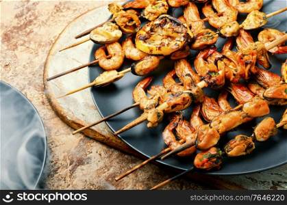 Delicious roasted shrimps and mussels on wooden skewers. Grilled shrimp and mussels skewers
