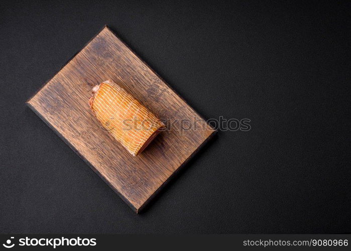 Delicious roll with meat, cheese, mushrooms, spices and herbs on a dark textured concrete background