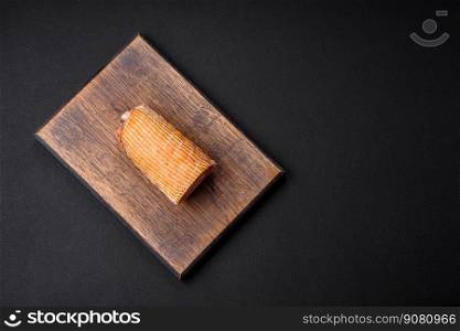 Delicious roll with meat, cheese, mushrooms, spices and herbs on a dark textured concrete background