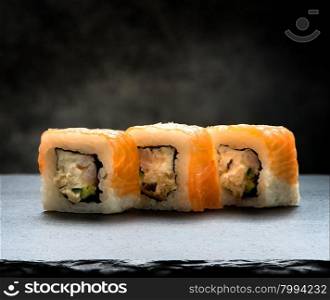 Delicious rolls on a slate table and black background