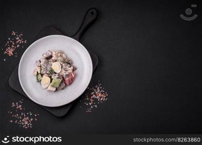 Delicious salad with boiled beef tongue, quail eggs, tomatoes and cucumber on a dark concrete background
