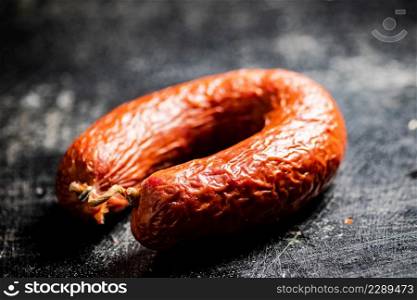 Delicious salami sausage on the table. On a black background. High quality photo. Delicious salami sausage on the table.
