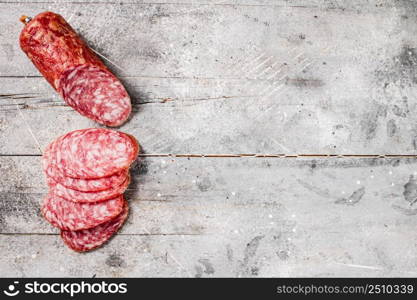 Delicious salami sausage on the table. On a gray background. High quality photo. Delicious salami sausage on the table.