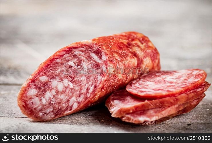 Delicious salami sausage on the table. On a gray background. High quality photo. Delicious salami sausage on the table.