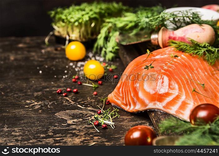 Delicious salmon fillet with aromatic herbs and spices on dark wooden background. Healthy food cooking concept. Close up