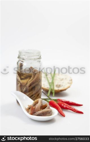 Delicious salted anchovies with oil on white background