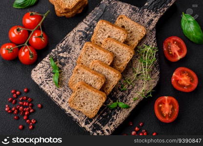 Delicious salted rectangular wheat croutons with salt and spices on a dark concrete background