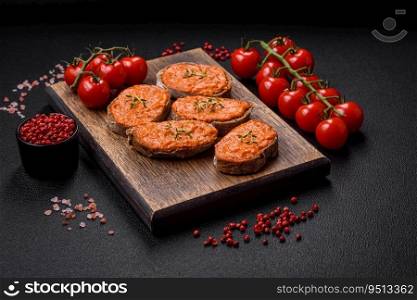 Delicious sandwich consisting of toast, red sauce with salt, spices and herbs on a dark concrete background