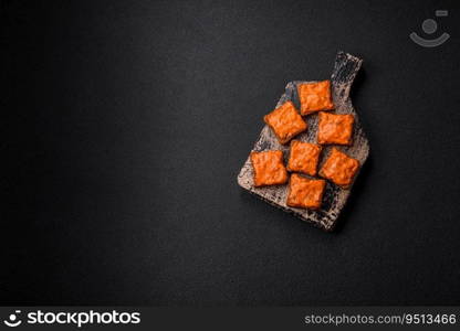 Delicious sandwich consisting of toast, red sauce with salt, spices and herbs on a dark concrete background