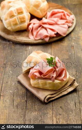 delicious sandwich on wooden table with mortadella sausage