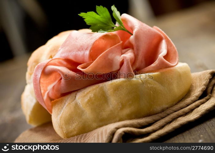 delicious sandwich on wooden table with mortadella sausage