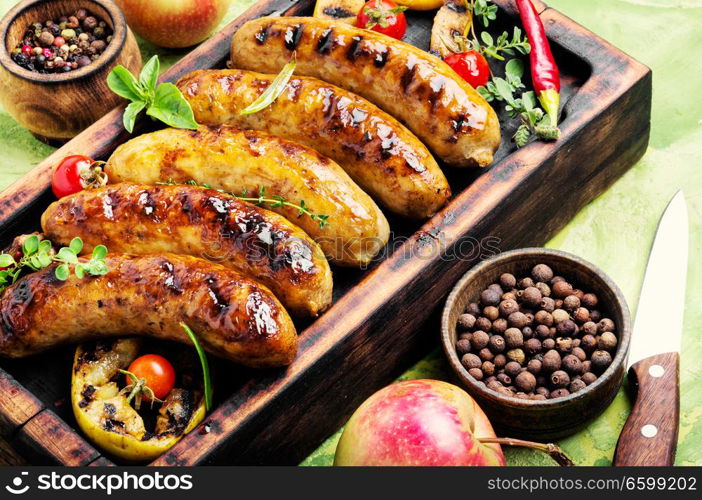 Delicious sausages grilled with spices and apples.Meat German food. Sausages fried with spices and apple