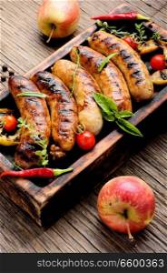 Delicious sausages grilled with spices and apples.Meat German food. Sausages fried with spices and apple