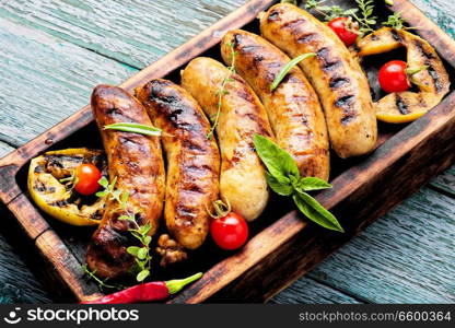 Delicious sausages grilled with spicy spices and apples.BBQ. Grilled sausages on cutting board