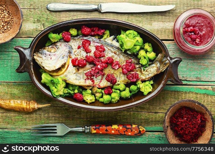 Delicious sea bream baked with raspberries and broccoli. Dorado fish. Appetizing gilthead fish in berry sauce.